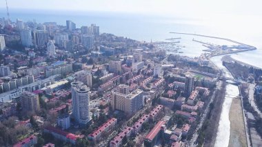 Yat körfezi olan deniz kenti manzarası. Şarjör. Güneşli bir günde yat körfezi ve deniz ufkunun arka planında sahil şehrinin güzel manzarası.