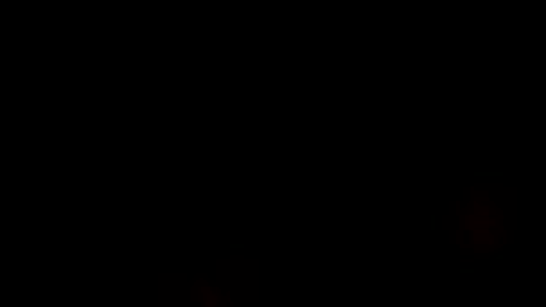 Detailní záběr barevných rozmazaných kulatých světel na černém pozadí. Záběry ze skladu. Bokeh pozadí, krásné zlaté kruhy explodující ohňostroj, Veselé Vánoce a Šťastný Nový rok koncept. — Stock video