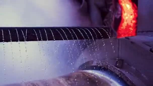 Solidification of hot metal in factory. Stock footage. Close-up of molten metal flowing to rotating cylinder with water installation. Smelting works at metallurgical plant — Stock Video