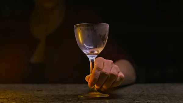 Bartender pours sparkling drink into clear glass. Stock footage. Close-up in transparent glass pour thick colored drink pearl. Cocktail bar
