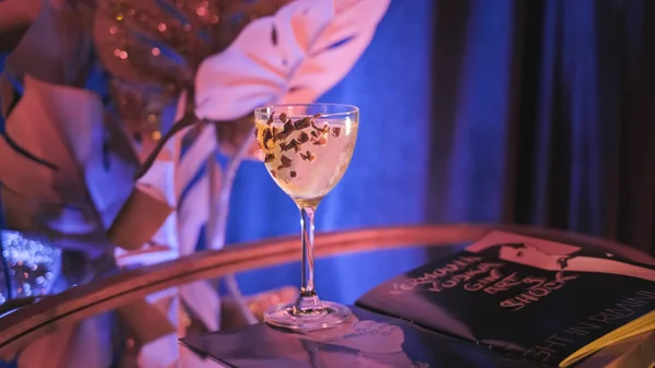 O barman pega o coquetel alcoólico decorado na mesa espelhada. Imagens de stock. Belo interior de bar de coquetel com luz de néon e bebida alcoólica preparada em mesa espelhada — Fotografia de Stock