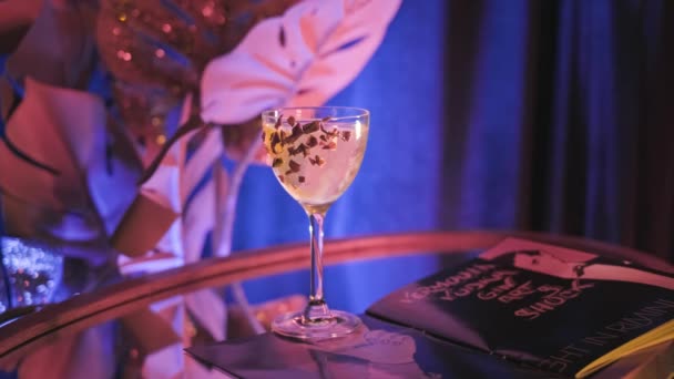 Barman pikt versierde alcoholische cocktail op gespiegelde tafel op. Voorraadbeelden. Prachtig interieur van cocktailbar met neon licht en geprepareerde alcoholische drank op spiegeltafel — Stockvideo