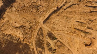 Tekerlek izleri ve kırmızı kamyonetli tozlu toprak yolun en üst manzarası. Sahne. Kamyon hareket ediyor ve havada tozlu bir iz bırakıyor, ağır tekerlekler, makine konsepti.