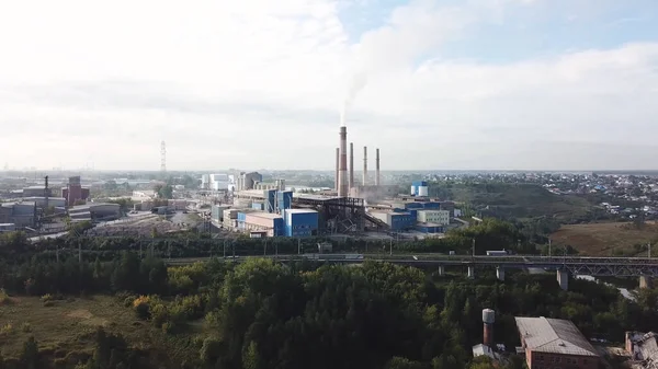 Aerial view of industrial area with chemical plant. Stock footage. Smoking chimney of the factory located near the city, air pollution and ecology concept.
