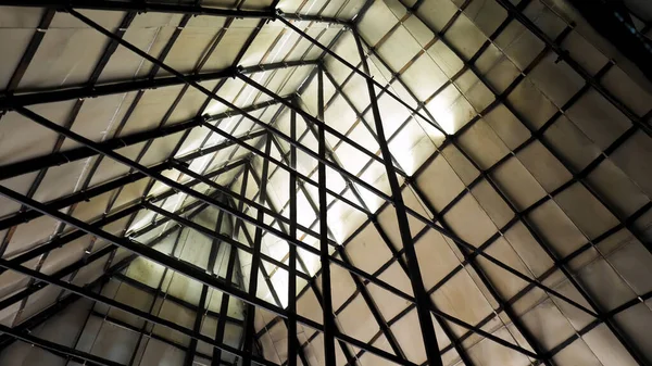 Secciones metálicas del techo de un almacén industrial. Imágenes de archivo. Vista inferior del techo triangular de chapas de madera contrachapada con estructura de acero de vigas metálicas . — Foto de Stock