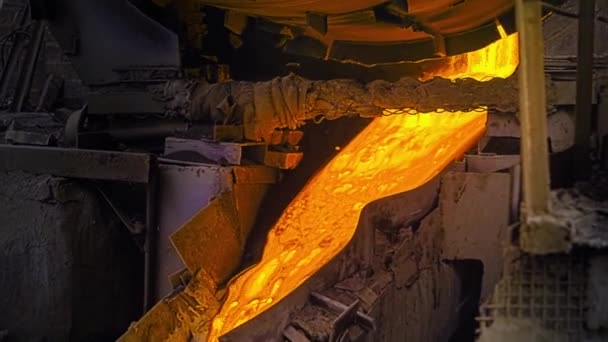 Primer plano del metal fundido que fluye en fábrica. Imágenes de archivo. Hermosa sustancia fundida fluye por el desagüe en la planta de acero. Operaciones de fusión y flujos de aleación brillante — Vídeo de stock