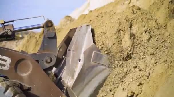 Close-up van de graafmachine die de grond opgraaft. Voorraadbeelden. Graven met behulp van graafmachine om ruimte vrij te maken voor de bouw — Stockvideo