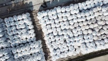 Endüstriyel bölgede içi dolu malzemelerle dolu bir açık hava deposunun üst görüntüsü. Stok görüntüleri. Paketlenmiş yalıtım malzemelerinin birçok satırının hava görüntüsü.