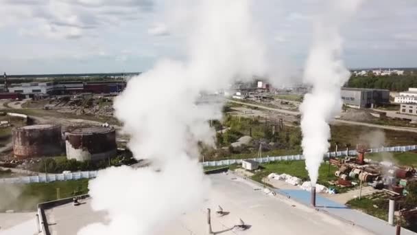 Vista aérea da fumaça que sai das chaminés da fábrica de cimento na área da cidade. Imagens de stock. Conceito de ecologia, empresa industrial no fundo azul céu nublado . — Vídeo de Stock