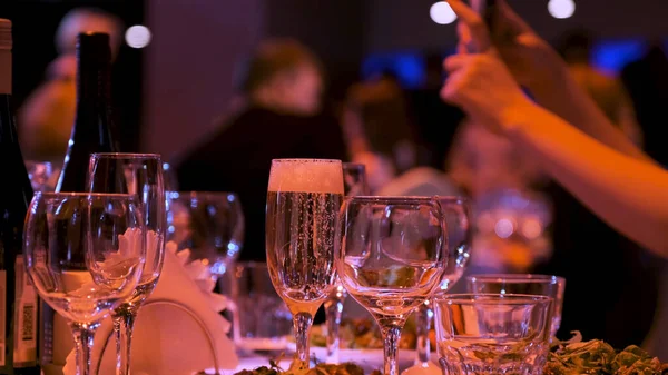 Großaufnahme einer Hand, die an der Bar oder im Restaurant Champagner ins Glas gießt. Archivmaterial. Alkohol-Hintergrund auf der Party, Feier-Konzept. — Stockfoto