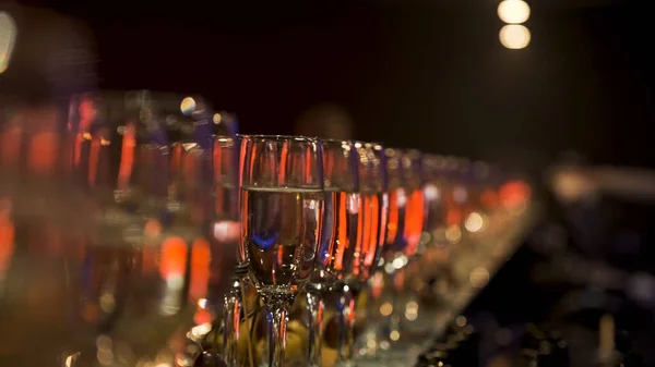 Viele Weingläser mit einem kühlen leckeren Champagner oder Weißwein an der Bar. Archivmaterial. Alkohol-Hintergrund auf der Party, Feier-Konzept. — Stockfoto