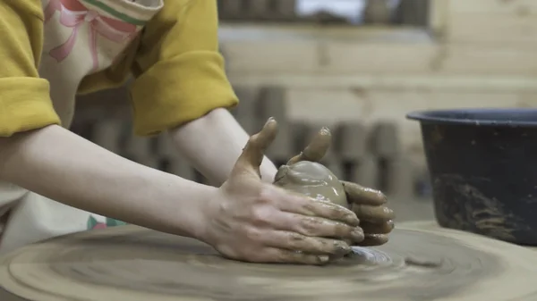 Classe di padrone su modellazione di argilla su una ruota di vasaio Nel laboratorio di ceramica. Filmati delle scorte. Primo piano delle mani della donna che creano qualcosa dall'argilla . — Foto Stock