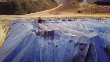 Kazı, ezilmiş taşların çıkarılması için işe yarar. Stok görüntüleri. Traktör yükleyicisinin üst görüntüsü enkaz ve çakıl taşlarını temizliyor