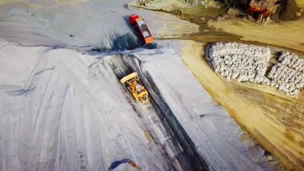 Trabajos de excavación para la extracción de piedra triturada. Imágenes de archivo. Vista superior de la cargadora de tractores limpiando montaña de escombros o guijarros — Vídeos de Stock