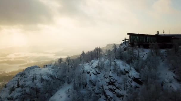 Top view of beautiful landscape from ski resort with track in winter. Stock footage. Top of ski slope with cafe on background of winter cloudy sunset among mountains — Stock Video