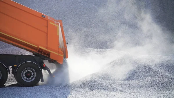 Dump truck pours out pile of rubble. Stock footage. Dump truck on construction site pours rubble on background of pile of rocks