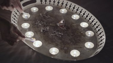 Mumlarla yanan kağıdın sihirli ayini. Stok görüntüleri. Noel 'den önce kehanetleri kapatan kadınlar, metal tepside, geleneklerde ve batıl inançlarda küçük kağıt parçalarını yakıyor..