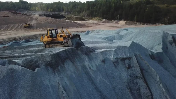 Big yellow excavator working in gravel quarry. Stock footage. Professional Mining industry concept, large construction excavator of yellow color at the construction site located in the industrial zone