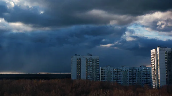 Timelapse de nubes de lluvia. Acción. Edificios de gran altura en los suburbios cerca de la estepa en el fondo de nubes de movimiento rápido y lluvia que se aproxima. Timelapse of moving cumulus clouds and rain — Foto de Stock