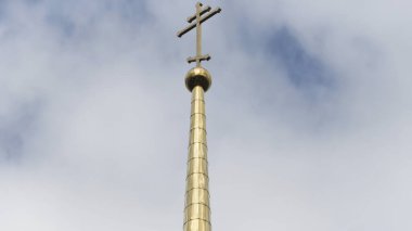 Gökyüzüne karşı bir Ortodoks kilisesinin altın kulesi. Stok görüntüleri. Tapınak ya da katedralin haçı olan uzun ve parlak bir kule manzarası, din kavramı..