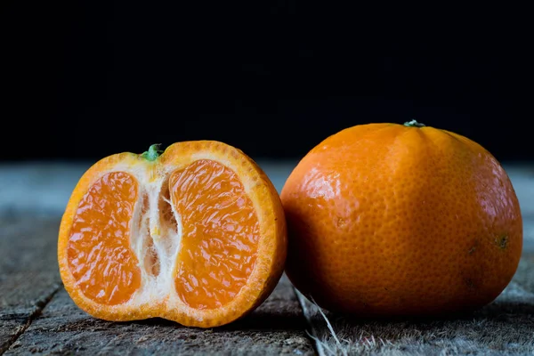 Erdbeeren und Mandarinen auf einem alten Holztisch in einem alten Bausatz — Stockfoto