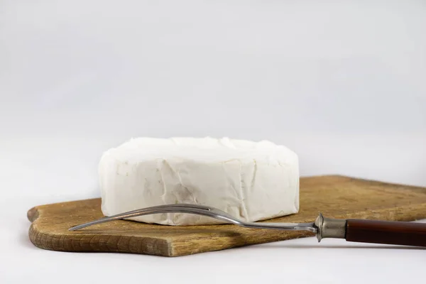 Witte kaas op witte geïsoleerde achtergrond op hakken bestuur — Stockfoto