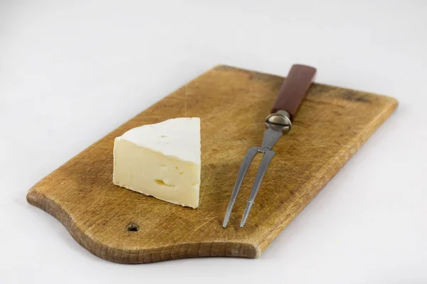 Witte kaas op witte geïsoleerde achtergrond op hakken bestuur — Stockfoto