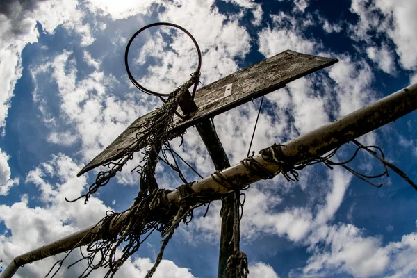 Velho campo de basquete, cesta, rede arrebatada contra o céu — Fotografia de Stock