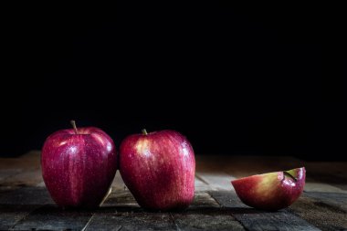Ahşap bir masa üzerinde kırmızı lezzetli ıslak elma