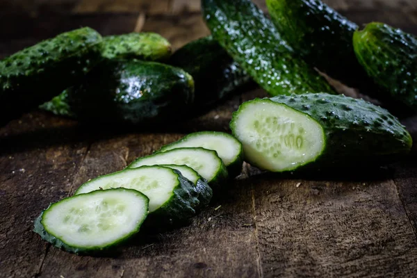 Smakelijke en verse grond komkommers op een houten keukentafel. — Stockfoto