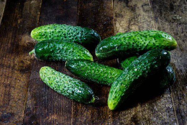 Tasty and fresh ground cucumbers on a wooden kitchen table. — Stock Photo, Image