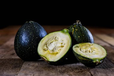 Mini bir ahşap masa, siyah arka plan üzerinde kabak