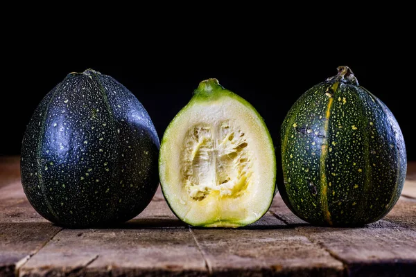 Mini calabaza sobre una mesa de madera, fondo negro —  Fotos de Stock