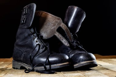 Ahşap bir masa üzerinde eski siyah Lehçe askeri bot.