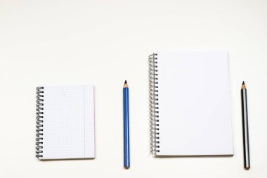 Şehvetli sketchbook ve boya kalemi beyaz bir tablo. Beyaz masa ve