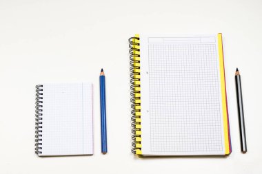 Şehvetli sketchbook ve boya kalemi beyaz bir tablo. Beyaz masa ve