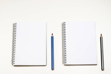 Şehvetli sketchbook ve boya kalemi beyaz bir tablo. Beyaz masa ve