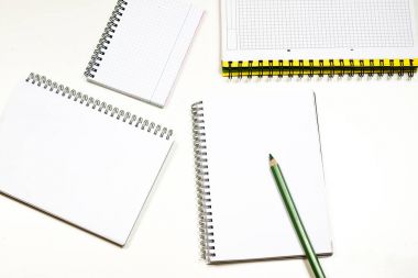 Şehvetli sketchbook ve boya kalemi beyaz bir tablo. Beyaz masa ve