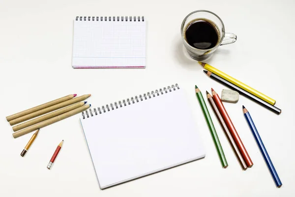 Café e caderno de esboços para desenhos. Mesa branca. Retrocesso isolado — Fotografia de Stock