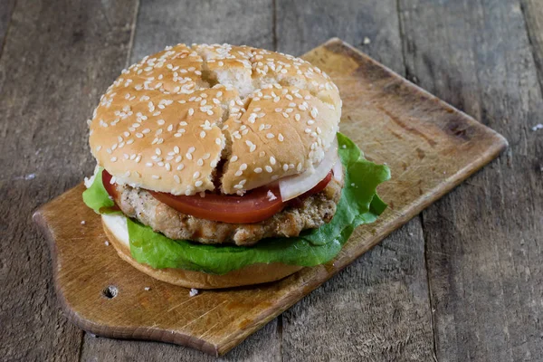 Rotolo con cotoletta arrosto. Hamburger su una tavola di legno. Scheda cucina — Foto Stock
