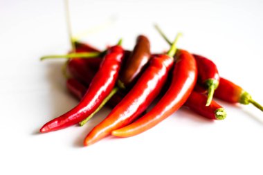 Mutfak masasının üstünde taze biber kırmızı sıcak. Beyaz arka plan.