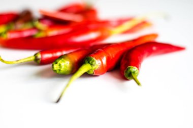 Mutfak masasının üstünde taze biber kırmızı sıcak. Beyaz arka plan.