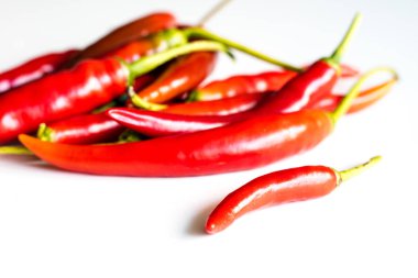 Mutfak masasının üstünde taze biber kırmızı sıcak. Beyaz arka plan.
