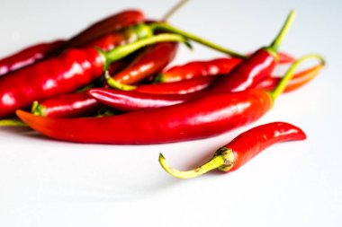 Mutfak masasının üstünde taze biber kırmızı sıcak. Beyaz arka plan.