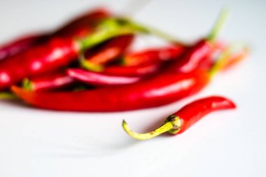 Mutfak masasının üstünde taze biber kırmızı sıcak. Beyaz arka plan.