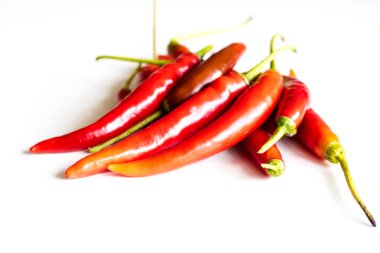 Mutfak masasının üstünde taze biber kırmızı sıcak. Beyaz arka plan.