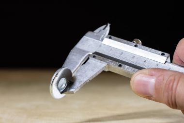 Eski iyi Kaliper karın ölçme sırasında elinde. Ahşap sekmesi