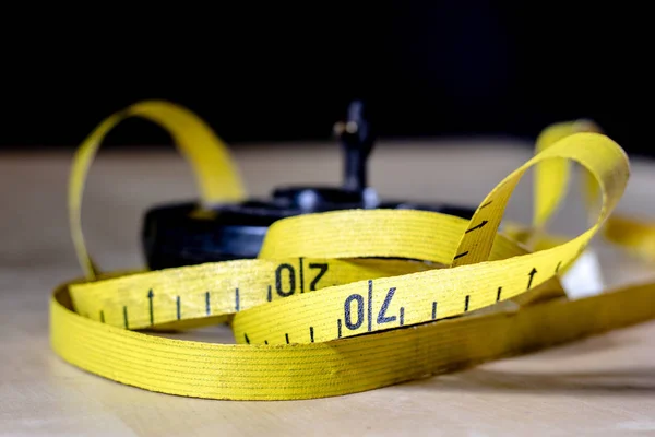 Tape for measuring in the field. A measure tangled on a wooden t — Stock Photo, Image