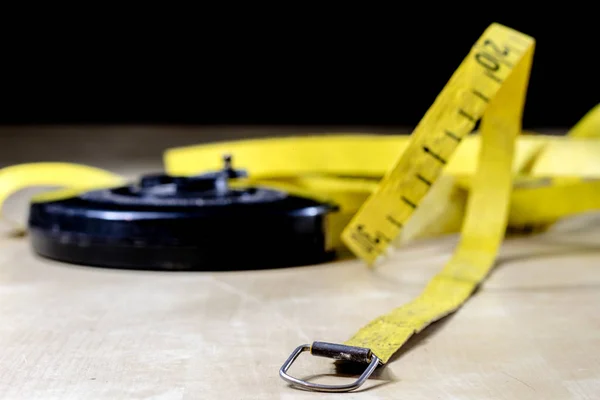 Tape for measuring in the field. A measure tangled on a wooden t — Stock Photo, Image