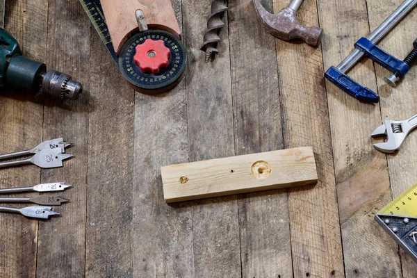 Nástroje na dřevěný stůl ve staré dílně. Uspořádány na okraji — Stock fotografie
